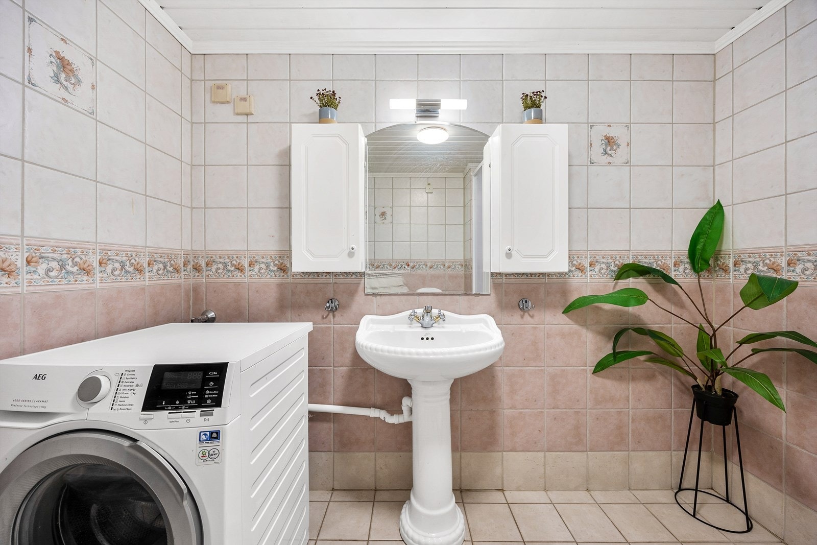 Badet er utstyrt med dusjkabinett, gulvstående wc og søyleservant med overskap Galleribilde