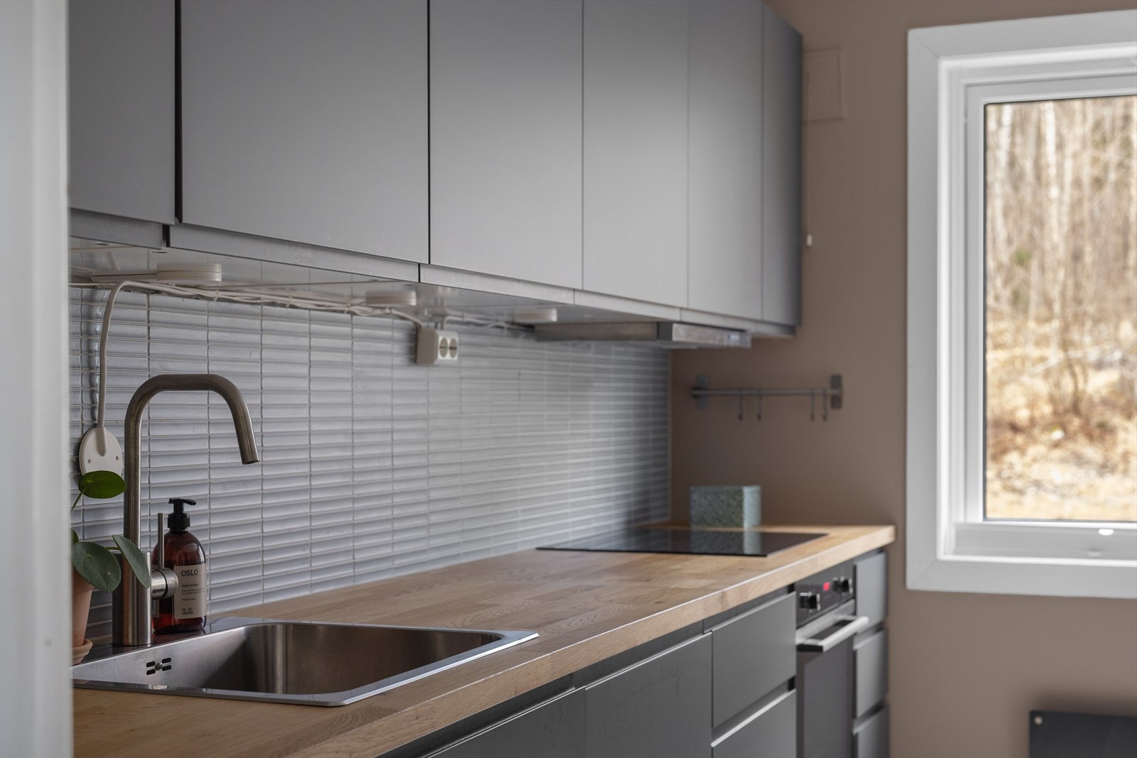 Benkeplaten er av laminat og heltre. Det er integrert kjøl/fryseskap, oppvaskmaskin, induksjonstopp, stekeovn, vannstoppsystem og komfyrvakt Galleribilde