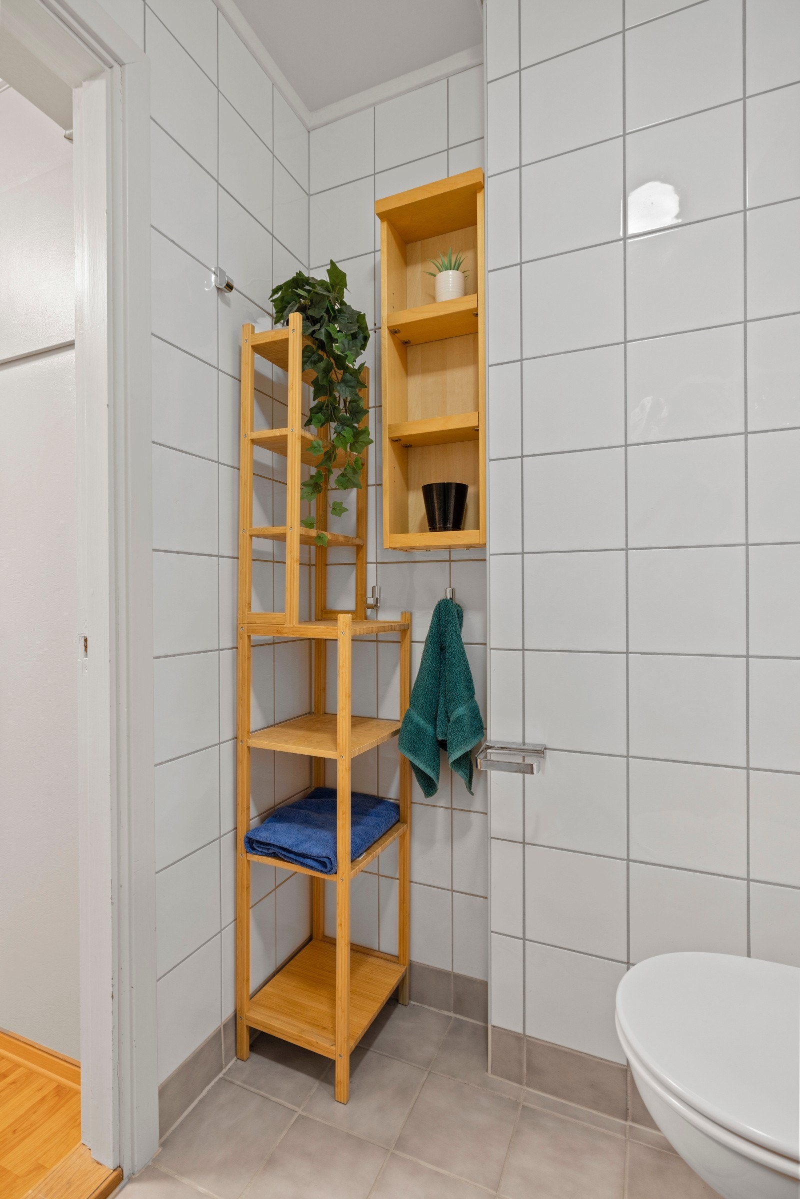 Rommet er utstyrt med en praktisk servant med slette fronter, veggmontert toalett og dusjvegger, samt opplegg for vaskemaskin Galleribilde