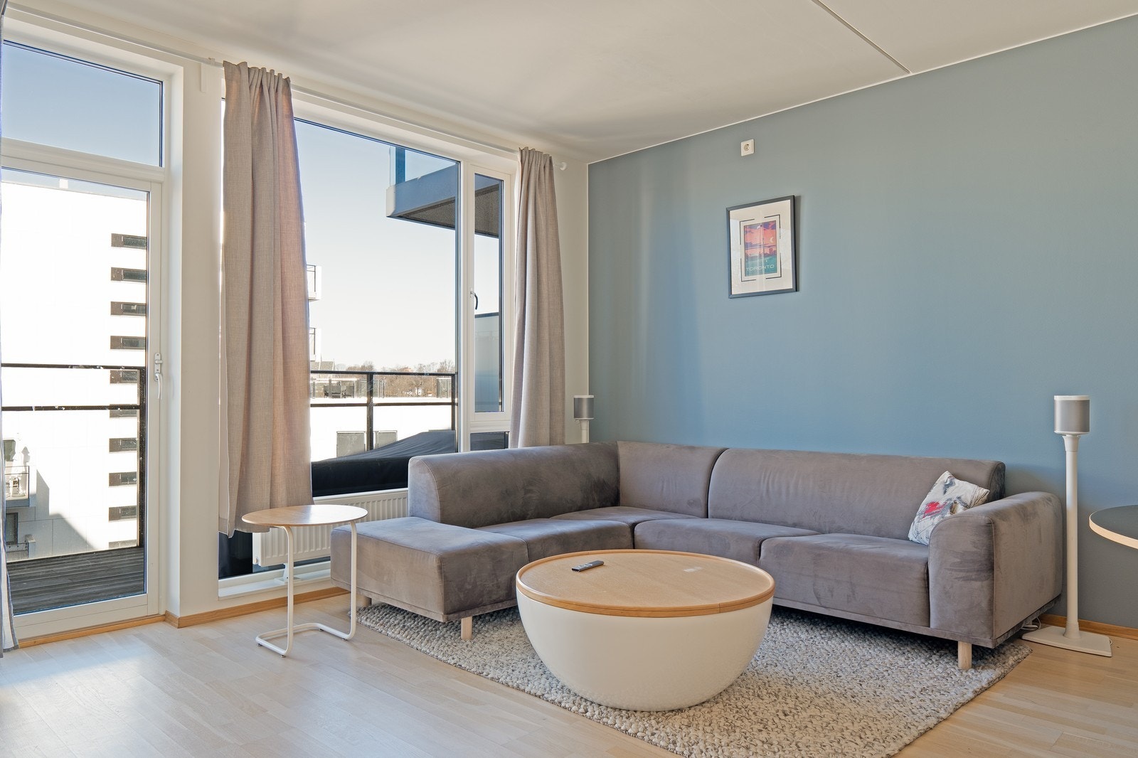 Lys og romslig stue med åpen løsning mot kjøkkenet med stilren innredning. Galleribilde