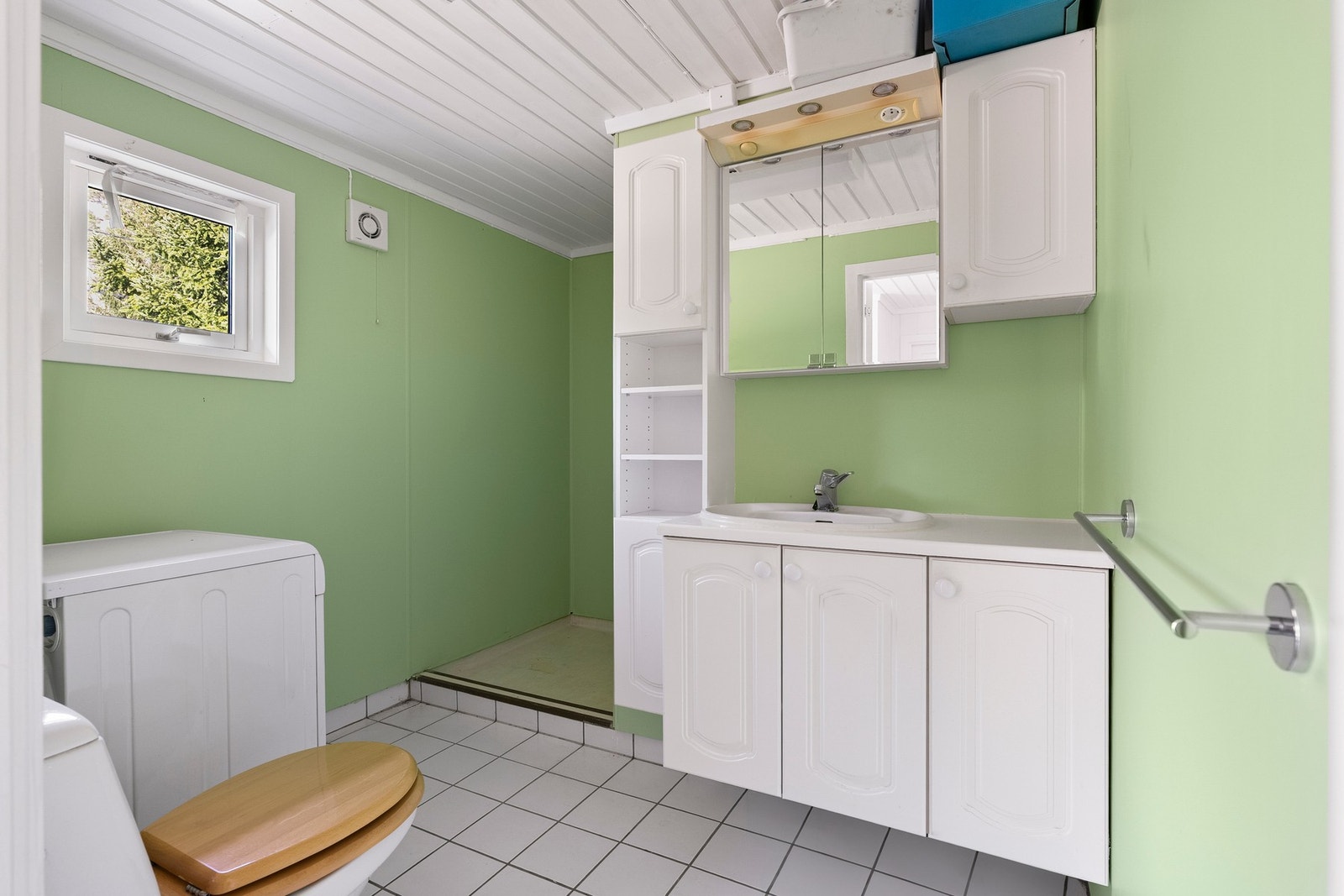 Badet tilbyr en funksjonell utforming med flislagt gulv og våtromsbelegg som er lett å holde rent. Galleribilde