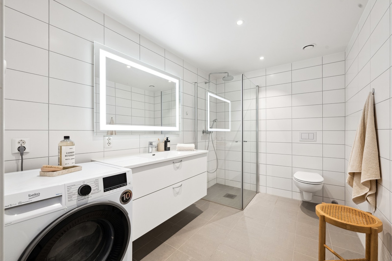 Lyst og moderne bad med opplegg til vaskemaskin Galleribilde