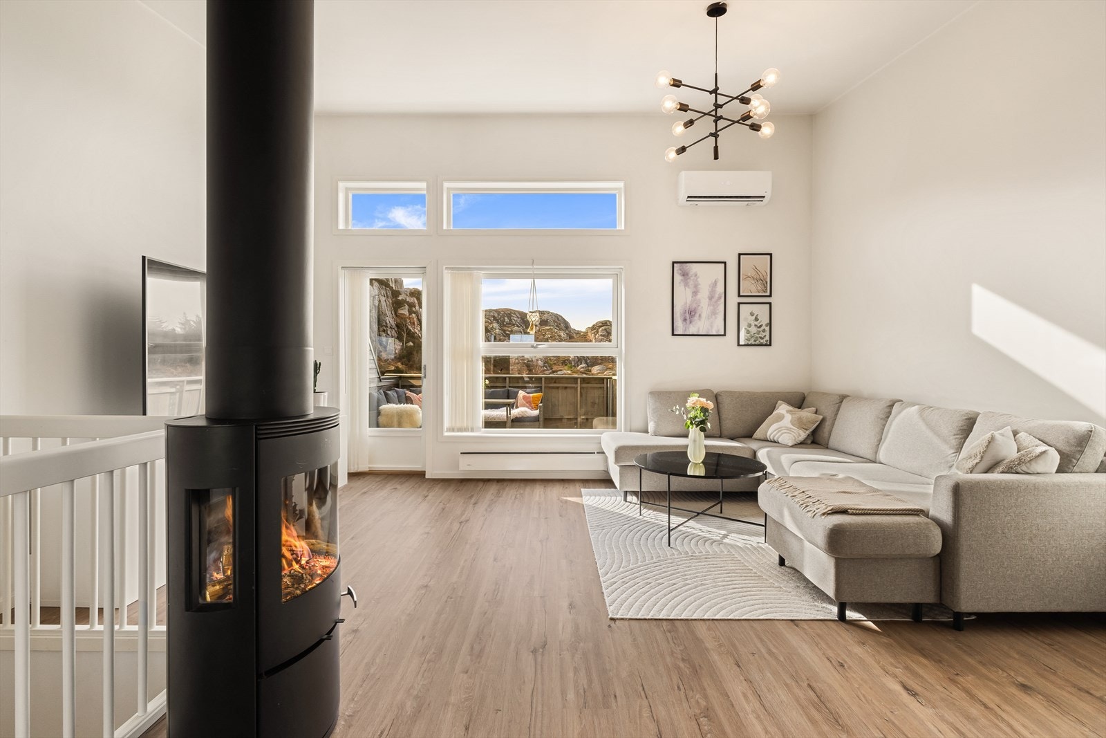 Store vindusflater slipper inn rikelig med dagslys, og en vedovn bidrar til både varme og hygge Galleribilde