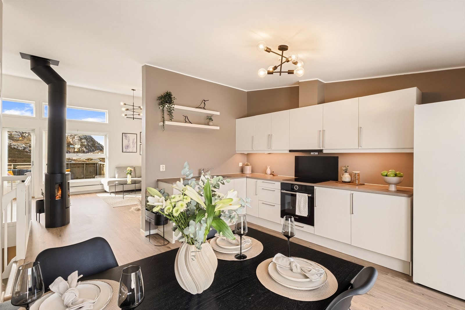 Boligen har en delvis åpen og innbydende planløsning mellom stue og kjøkken, noe som skaper en sosial atmosfære Galleribilde