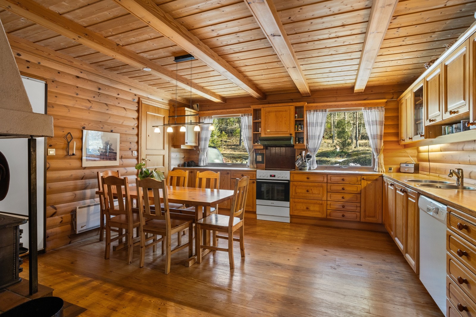 Separat kjøkken av god størrelse med vedovn og god plass til spisebordet. Galleribilde