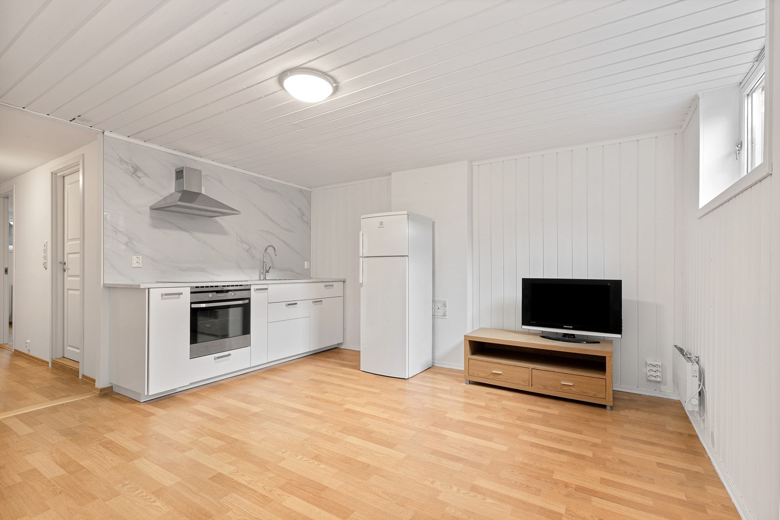 Kjellerstue med kjøkkenkrok og moderne innredning. Galleribilde