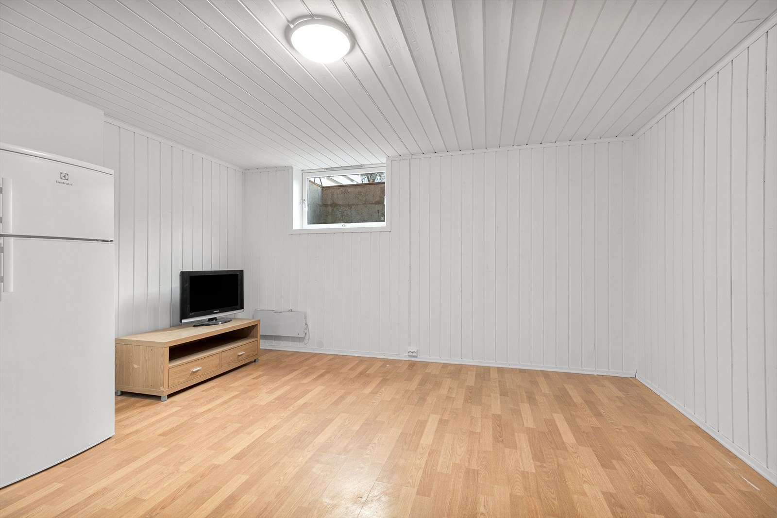 Kjellerstue med plass til både TV-krok og oppbevaring. Galleribilde