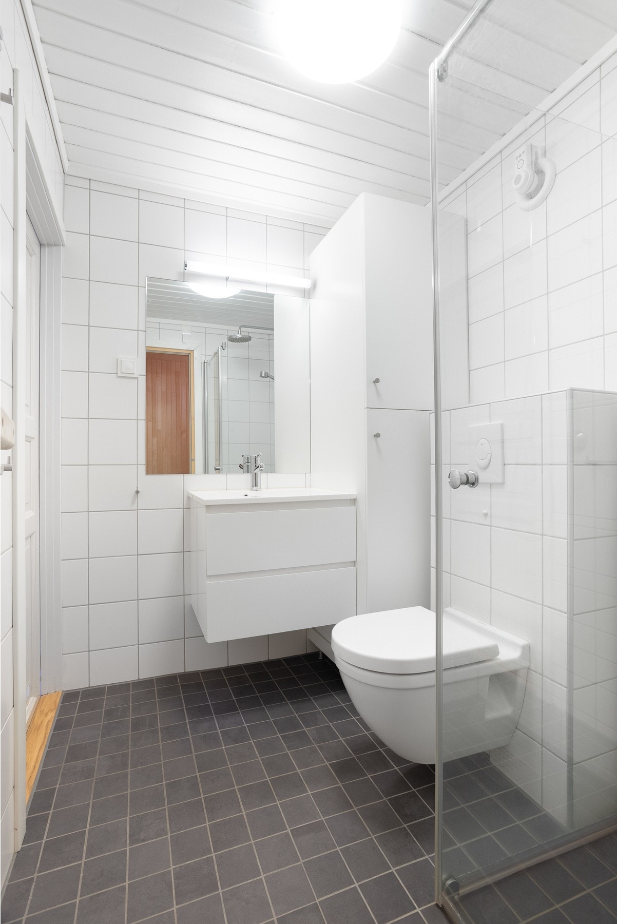 Moderne baderom oppusset i 2012, med vegghengt toalett, innredning med servant og dusj hjørne. Flislagte vegg- og gulvflater Galleribilde