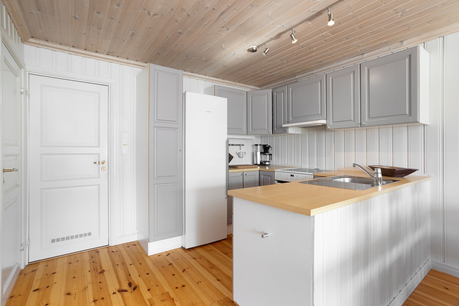 Klassisk, malt kjøkkeninnredning med mye skap og benkeplass. Galleribilde