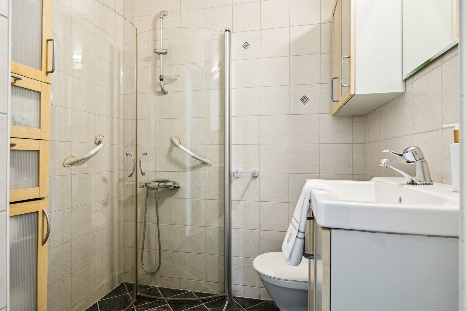 Badet er flislagt med innredning av servant med overskapp. Galleribilde