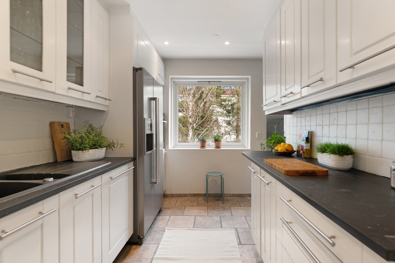 Det er lagt rustikke fliser over kjøkkenbenk som ble malt i 2025, og rommet har downlights belysning. Galleribilde