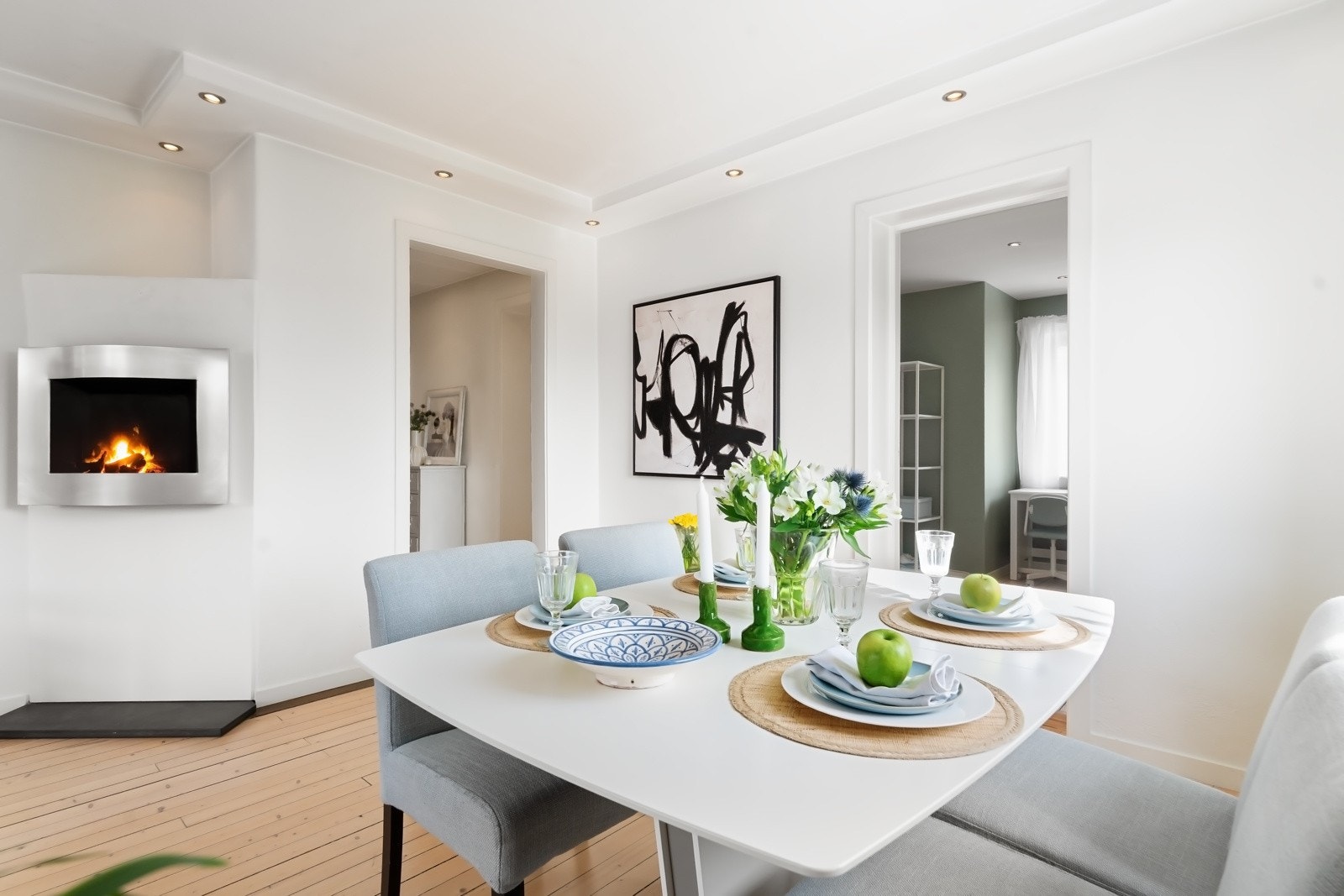 Peisen i bakgrunn er vinklet både mot sofa- og spisesone. Galleribilde