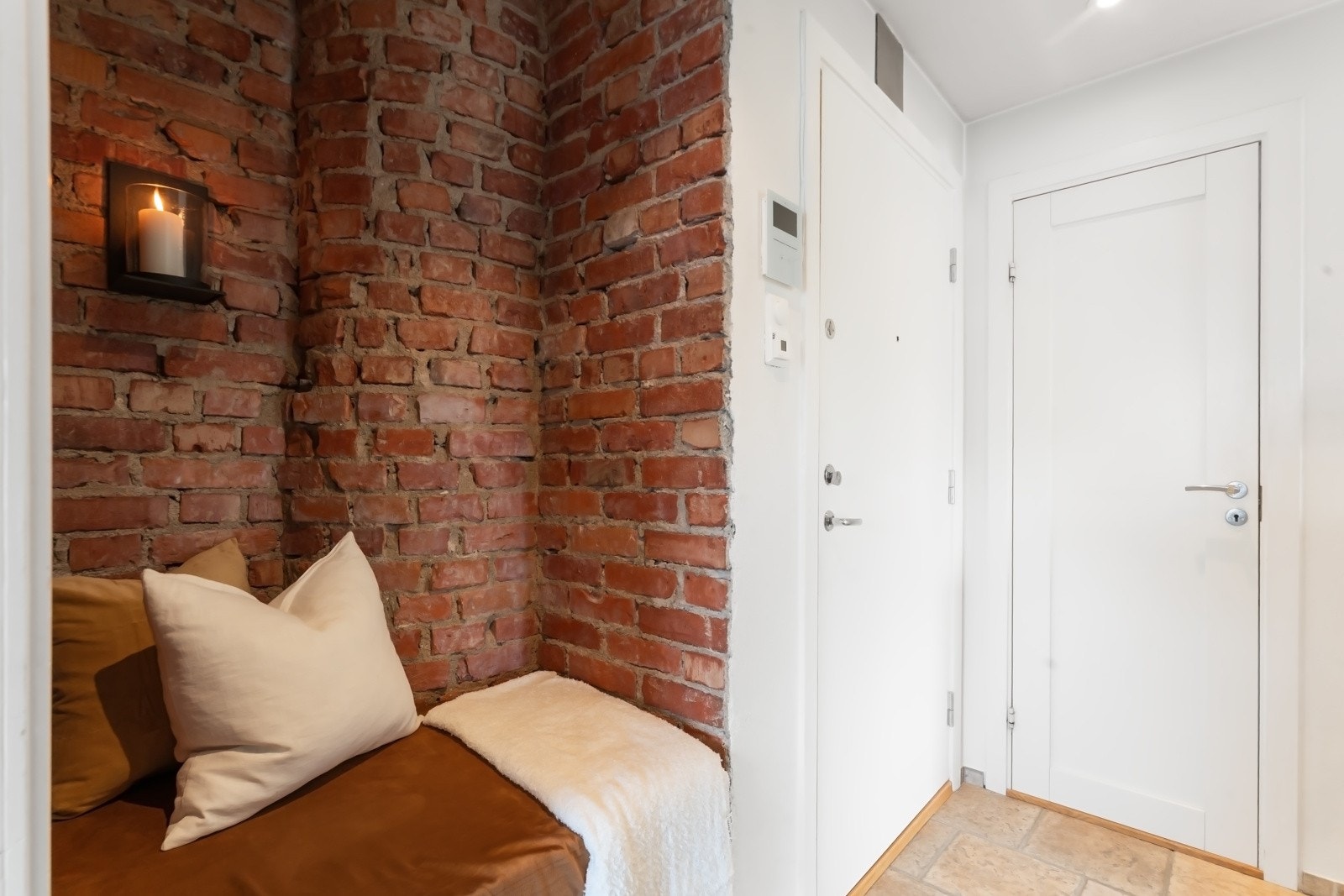 Lengre inn i entreen er det en nisje med mursteinsvegg som idag er innredet med sittebenk og veggbelysning. Galleribilde