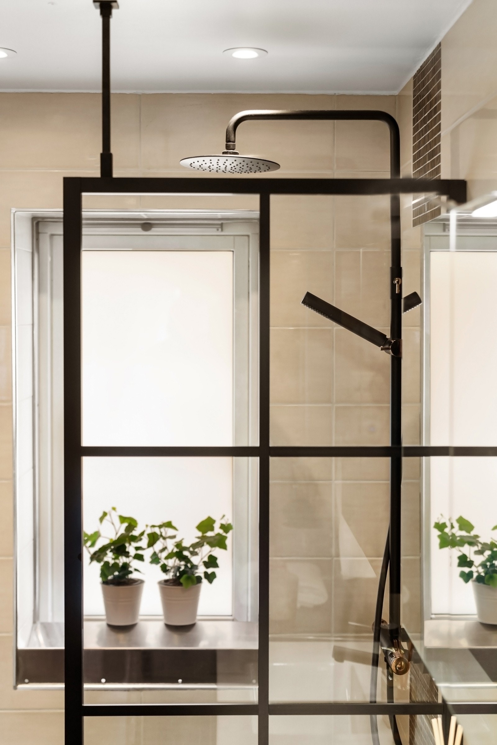 Det er dusjnisje med glassvegg og sort dusjarmatur. Galleribilde