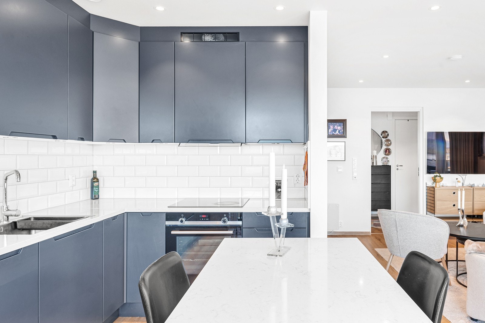 Tidløst kjøkken med slette fronter og benkeplate i stein. Galleribilde