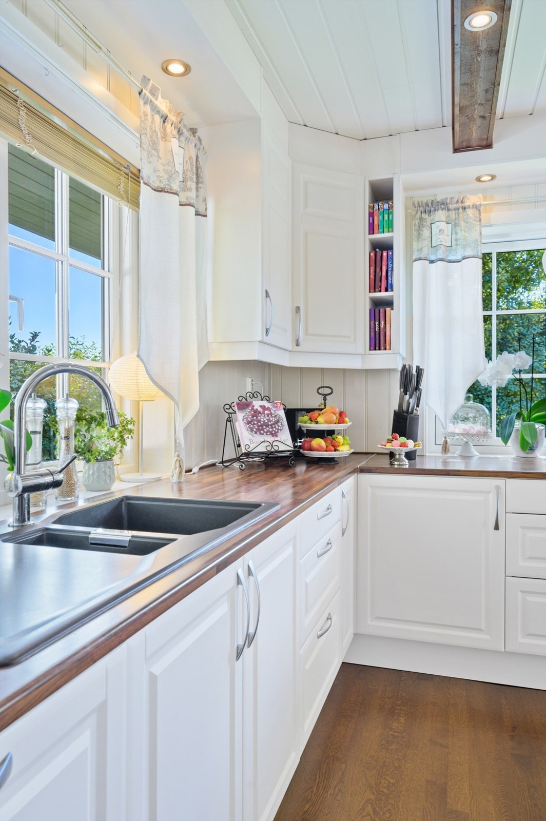 Over kjøkkenbenken er det vinduer med utsyn mot den fine hagen. Galleribilde