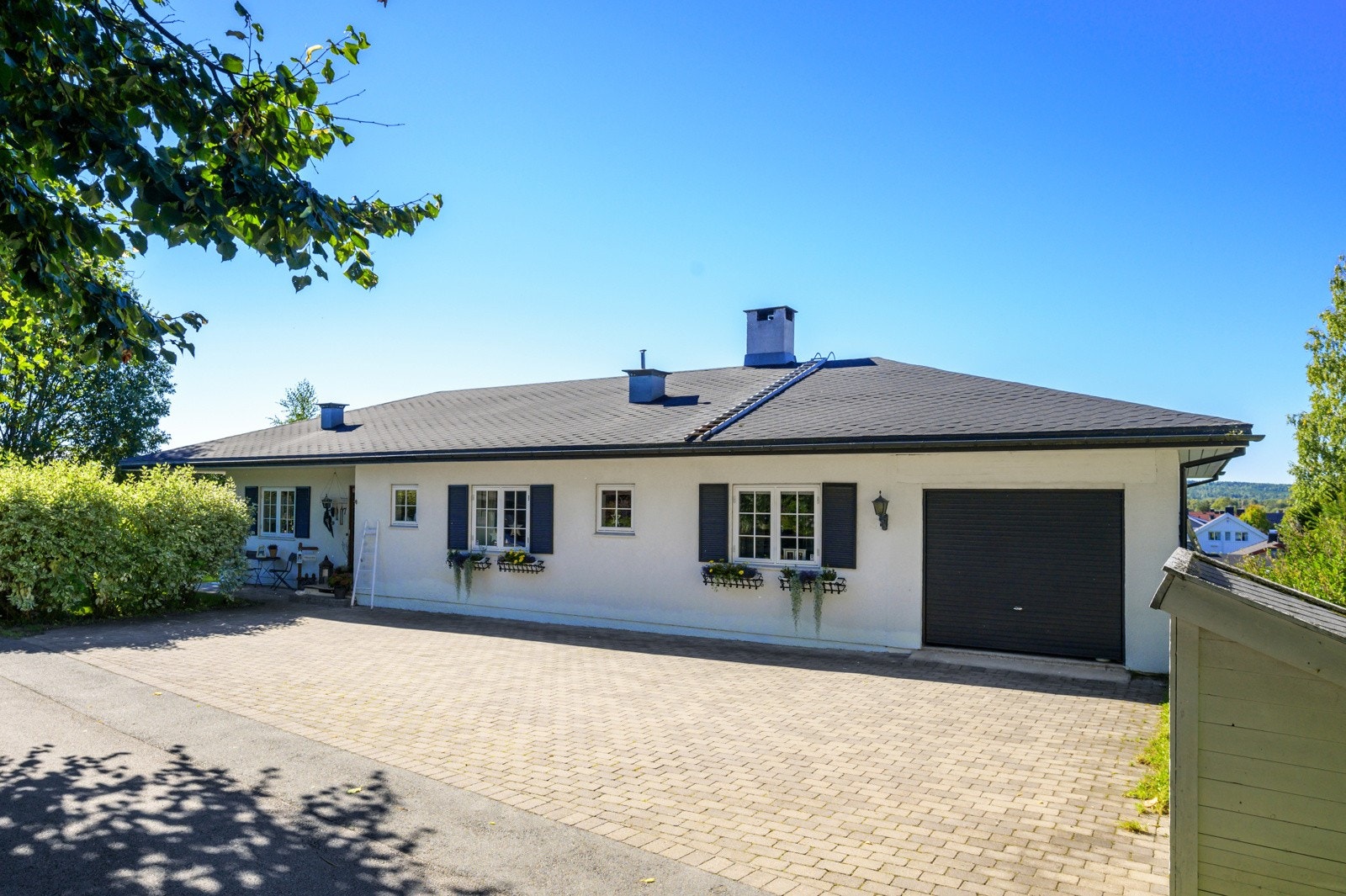 Eiendommen har innkjøring og parkering belagt med belegningsstein, noe som er enkelt å vedlikeholde. Galleribilde