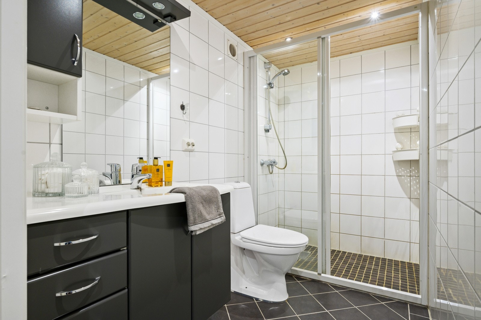 Boligen har et bad i hver etasje, samt eget vaskerom og ekstra toalettrom. Badet i 1.etasje har flislagte overflater, baderomsinnredning, toalett og stor dusj med glassdører. Galleribilde