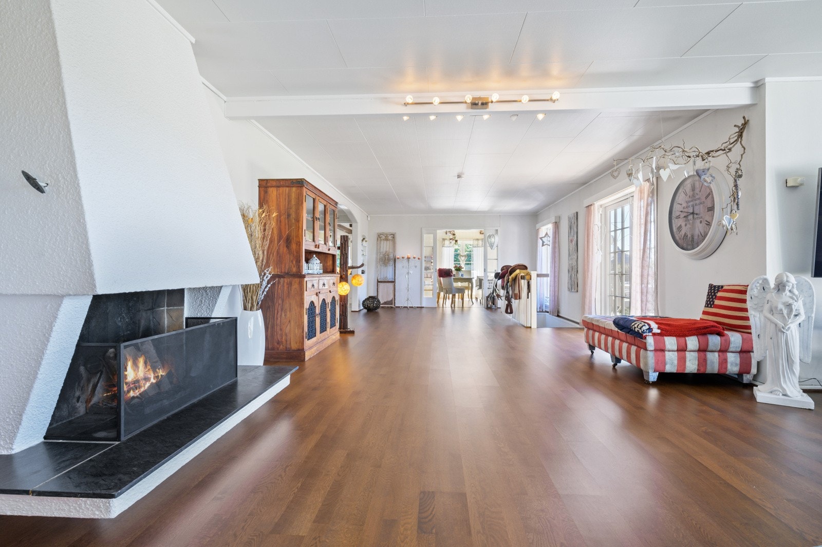 Stua har et pent parkettgulv og lysmalte overflater. Peisen skaper god stemning i rommet og gir ekstra varme på kalde vinterdager. Galleribilde