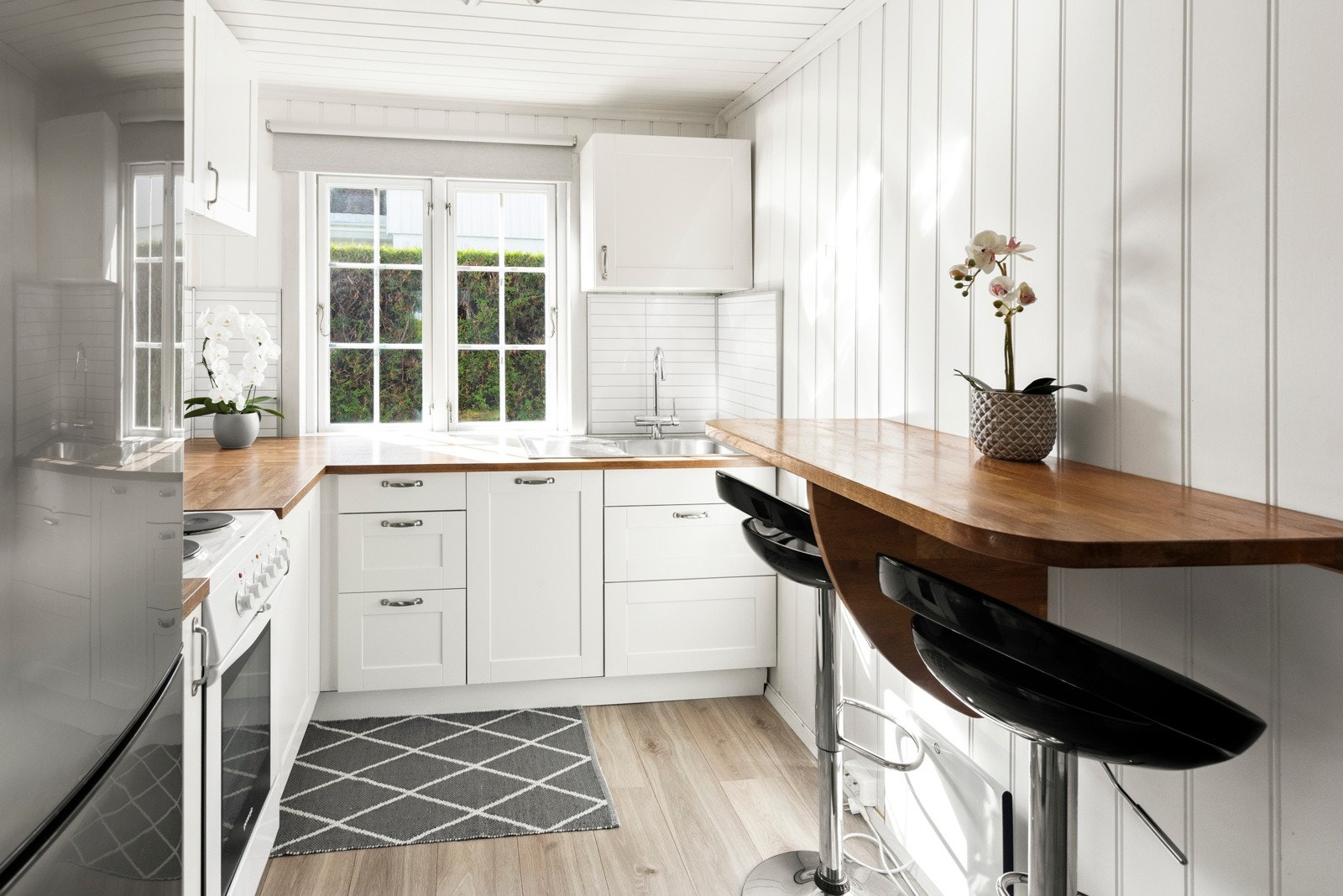 Kjøkken med lys innredning og integrert oppvaskmaskin Galleribilde