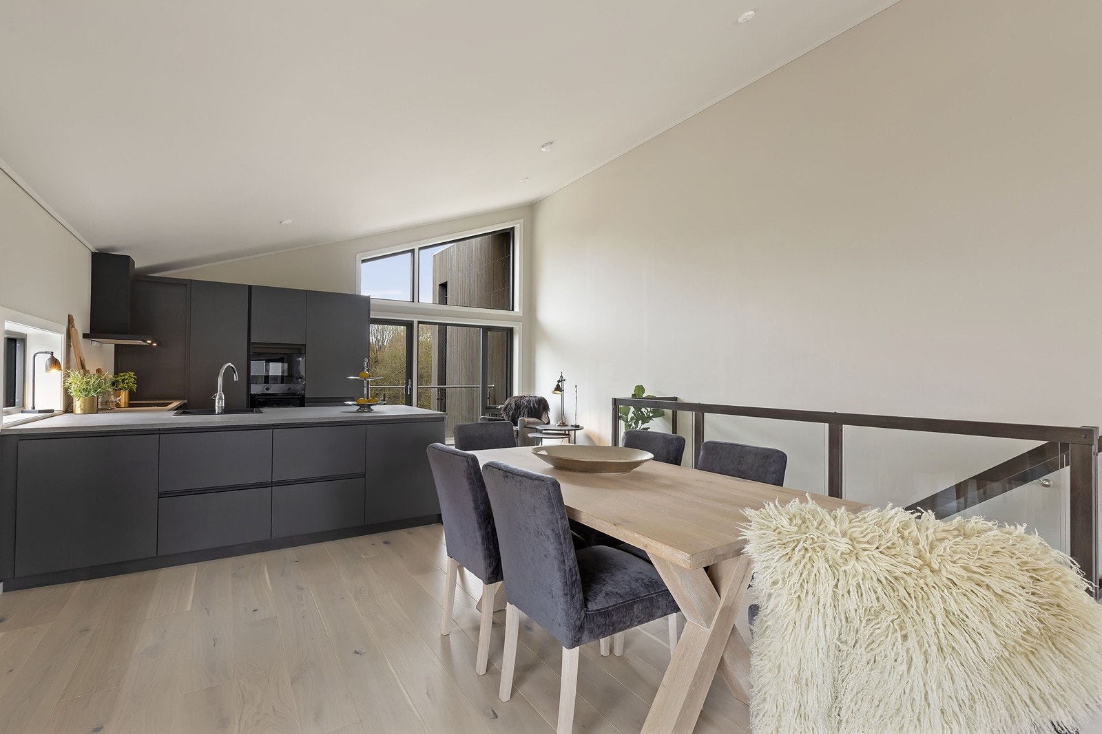 Kjøkkenet har stilren og moderne innredning, fra Sigdal, med slette grå fronter og sorte detaljer Galleribilde