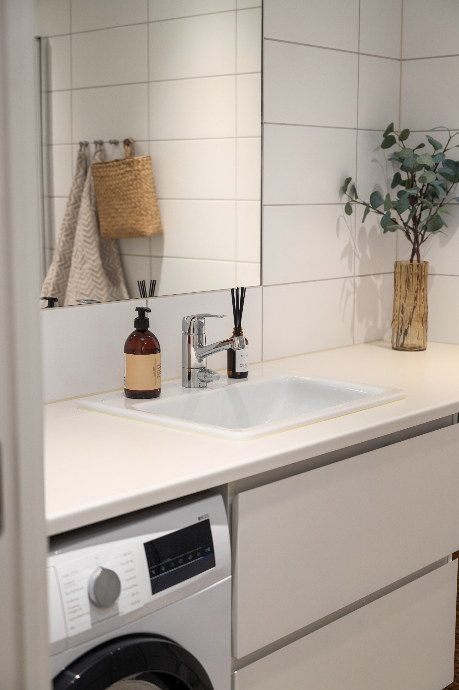 Rommet har vegghengt toalett med innebygget sisterne, servant med skuffeinnredning samt opplegg for vaskemaskin og tørketrommel Galleribilde