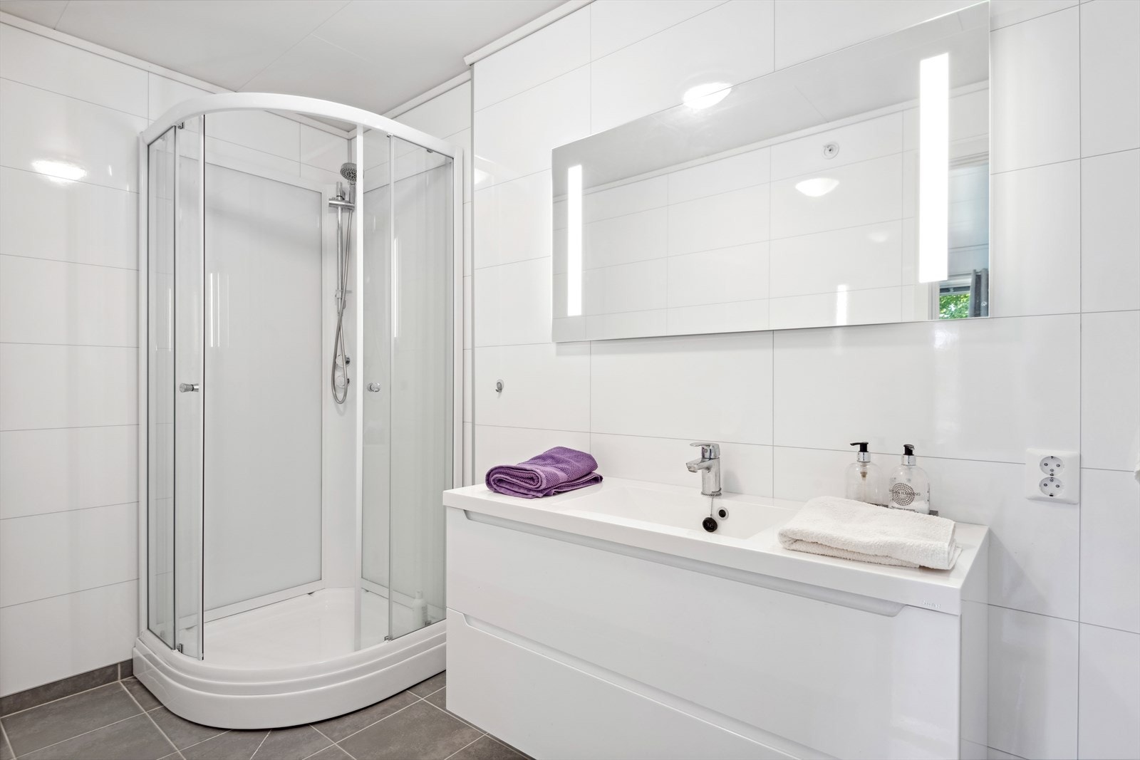 Baderommet som er tilknyttet hovedsoverommet er innredet med dusjkabinett, vegghengt toalett og servant med skuffer under Galleribilde