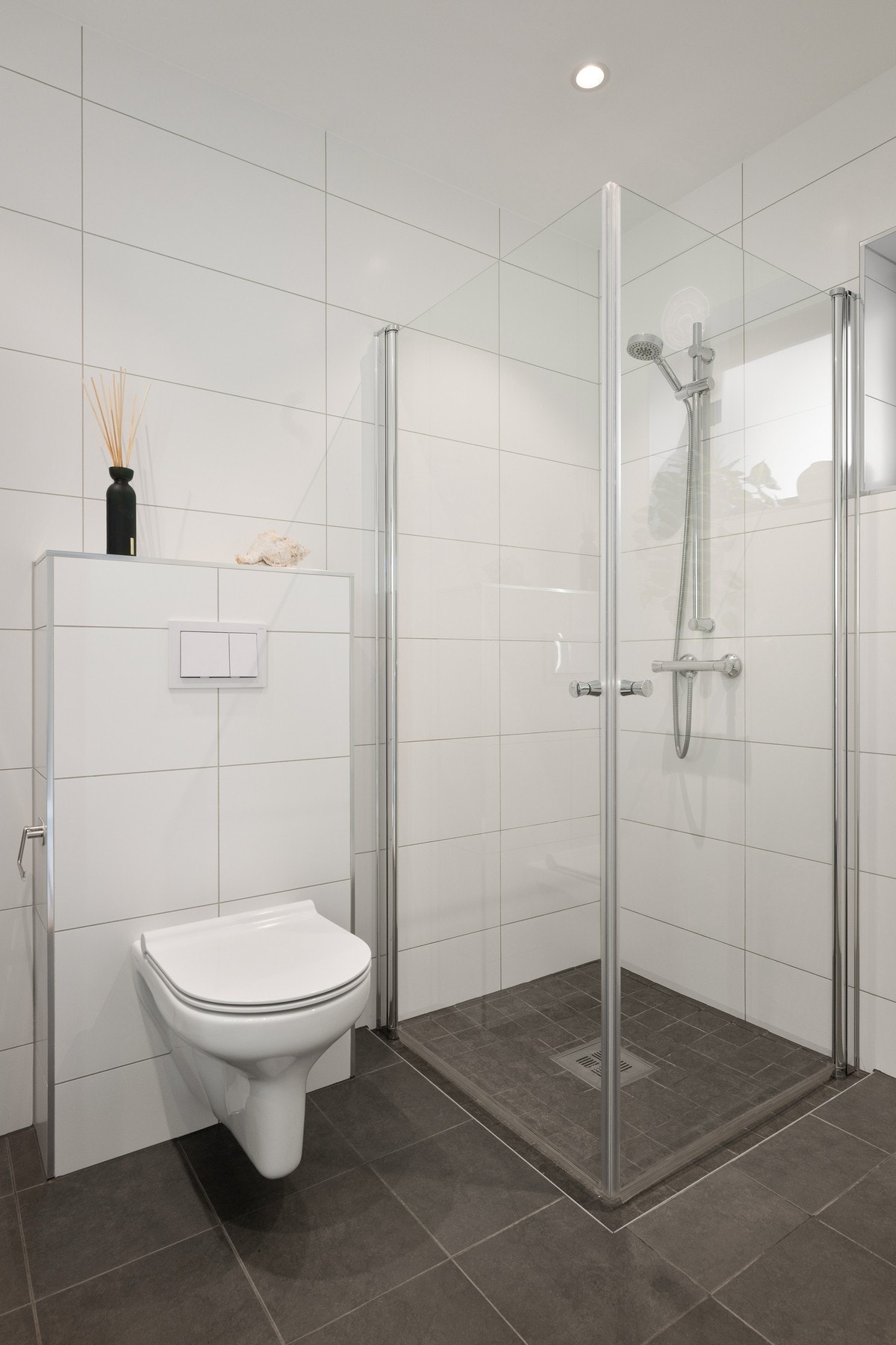 Badet har vegghengt toalett, dushjørne, servant med skuffeinnredning og opplegg for vaskemaskin. Galleribilde