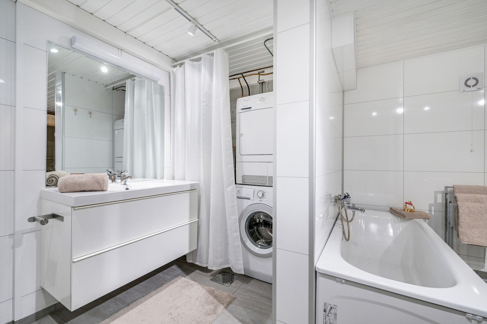 Badet er romslig med servant med speil og underskap, samt klosett og opplegg for vaskemaskin og tørketrommel (begge medfølger). Galleribilde