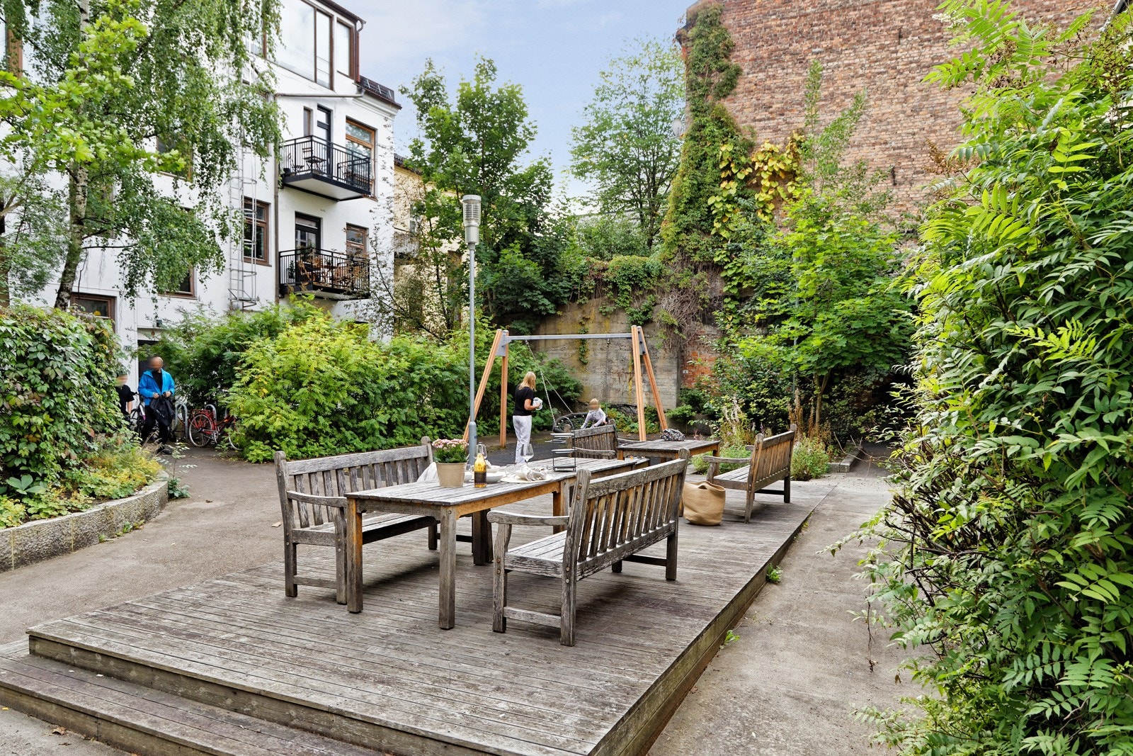 Store fine uteområder med grill, sitteplasser, huske og det er pent beplantet Galleribilde