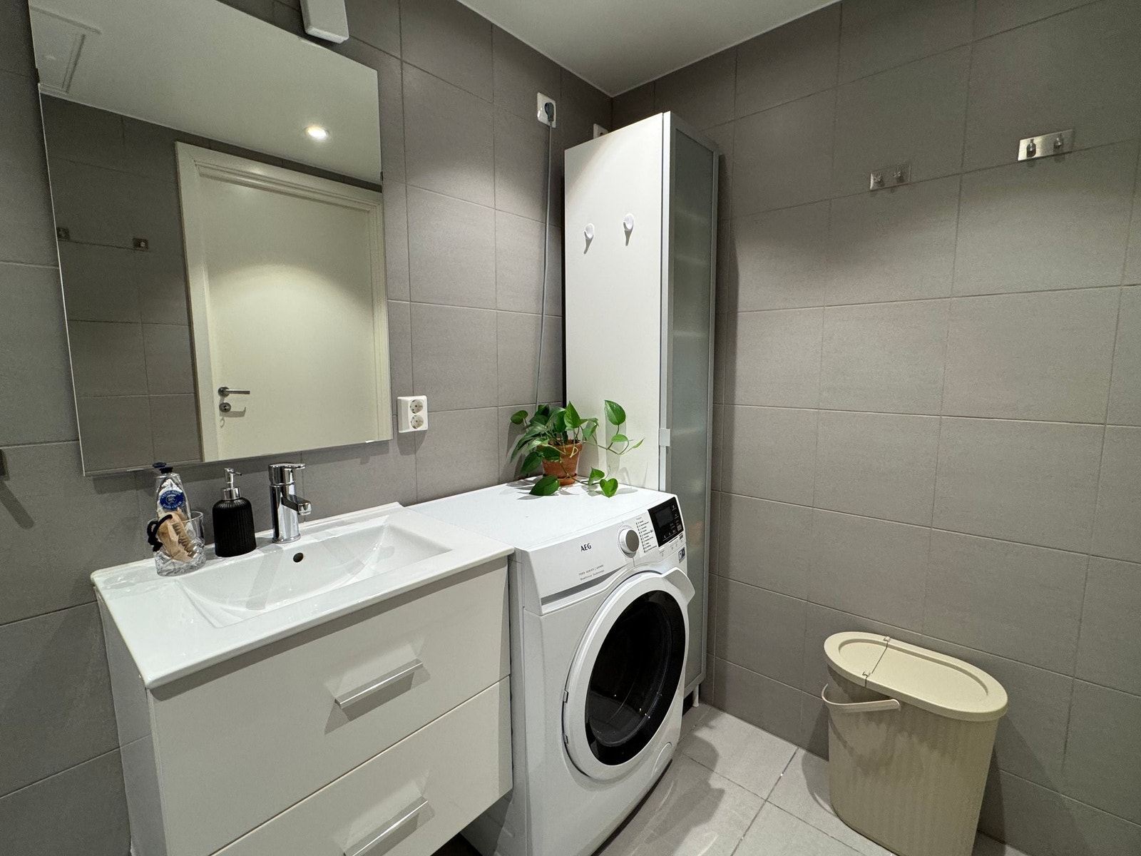 Badet har uttak for vaskemaskin, og plass til toalettartikler og annet under vask. Galleribilde