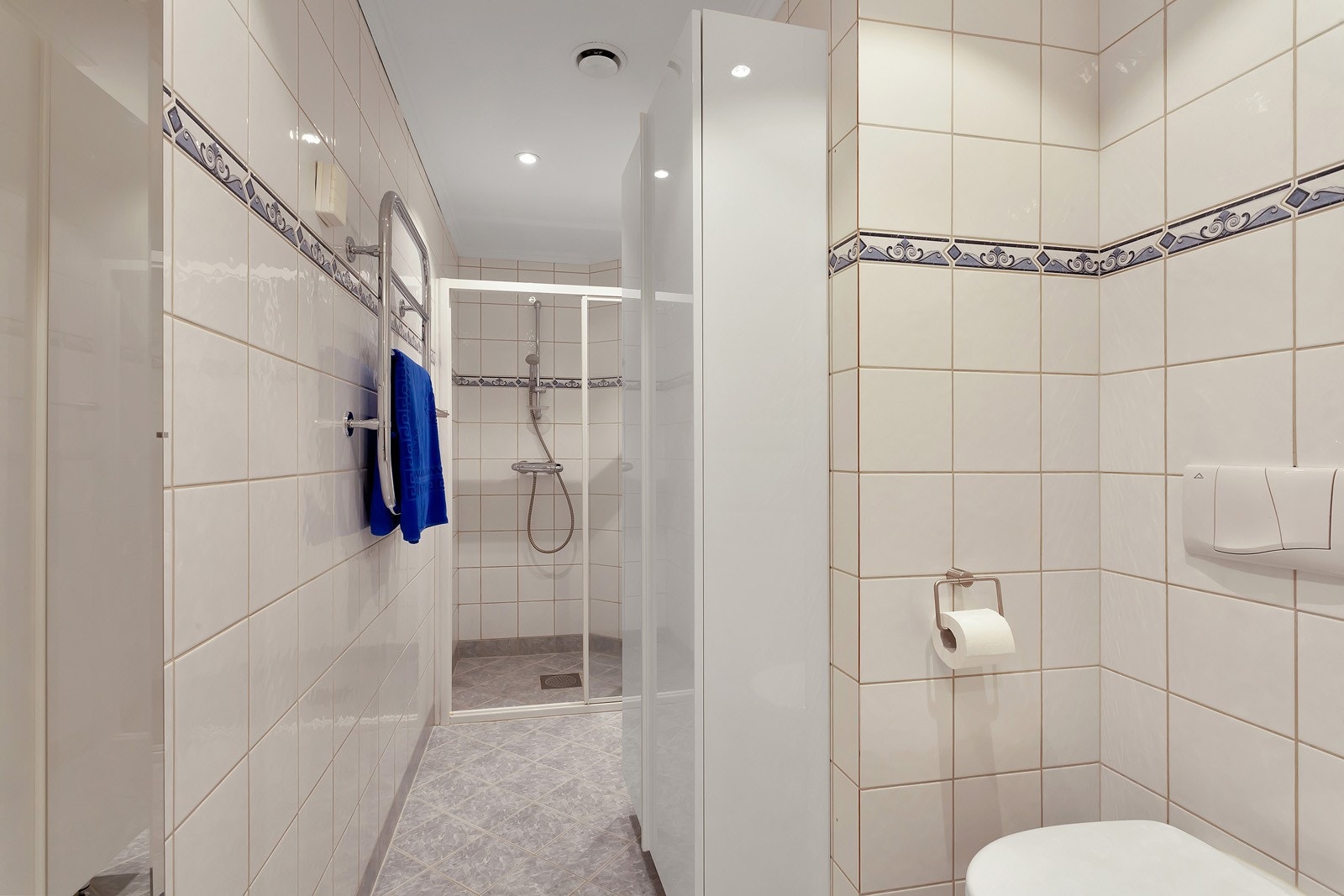 Badet er utstyrt med dusjhjørne og vegghengt toalett. Galleribilde