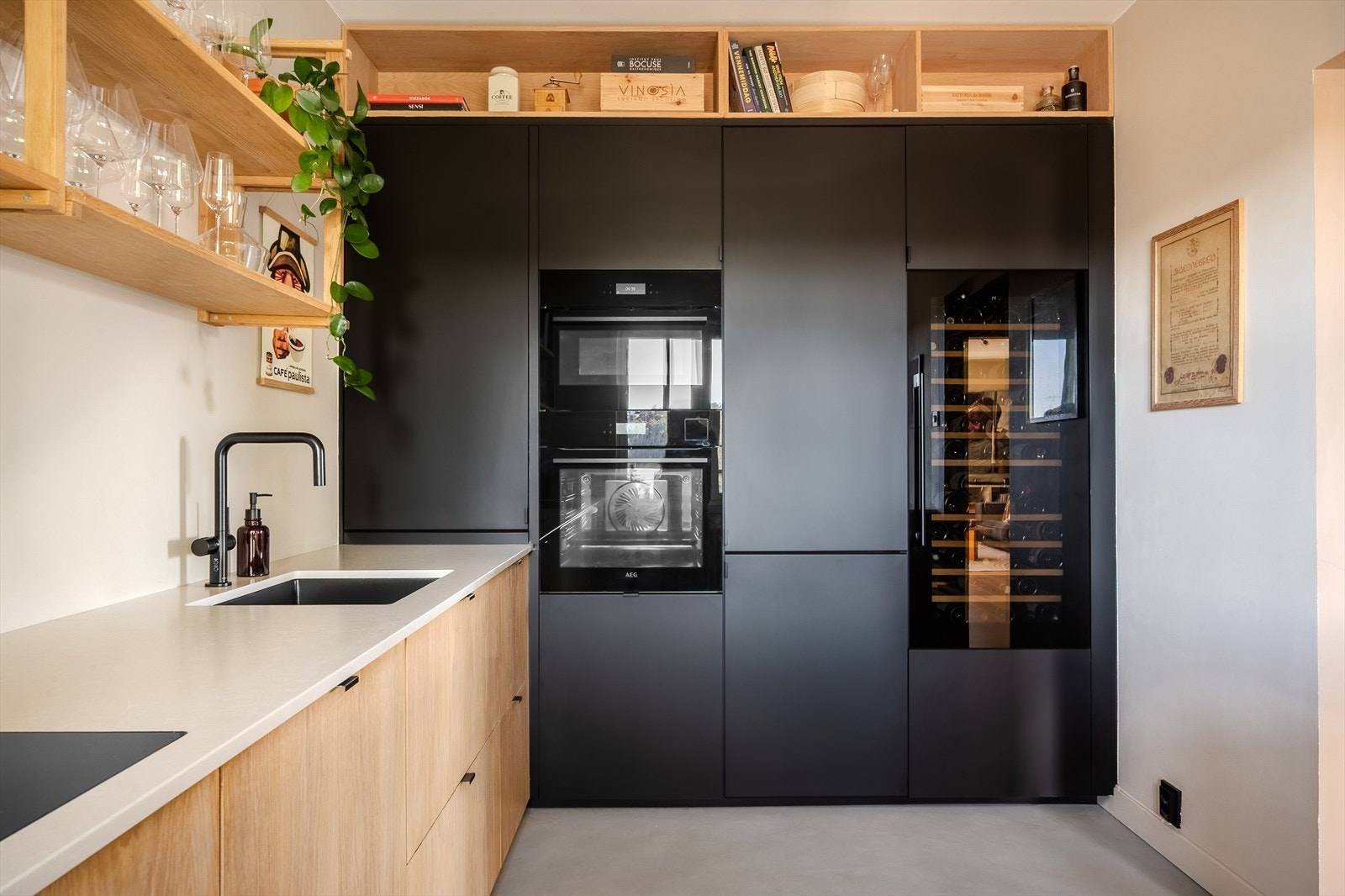 Kjøkkenet har et tidsriktig uttrykk med en kombinasjon av hyller, høyskap og benkeskap. Her er det godt med både skap- og benkeplass. Galleribilde