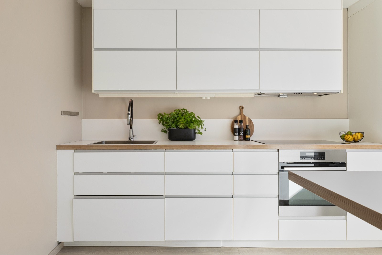 Det er store overflater med laminerte benkeplater, plateslått backsplash og slette skapfronter Galleribilde