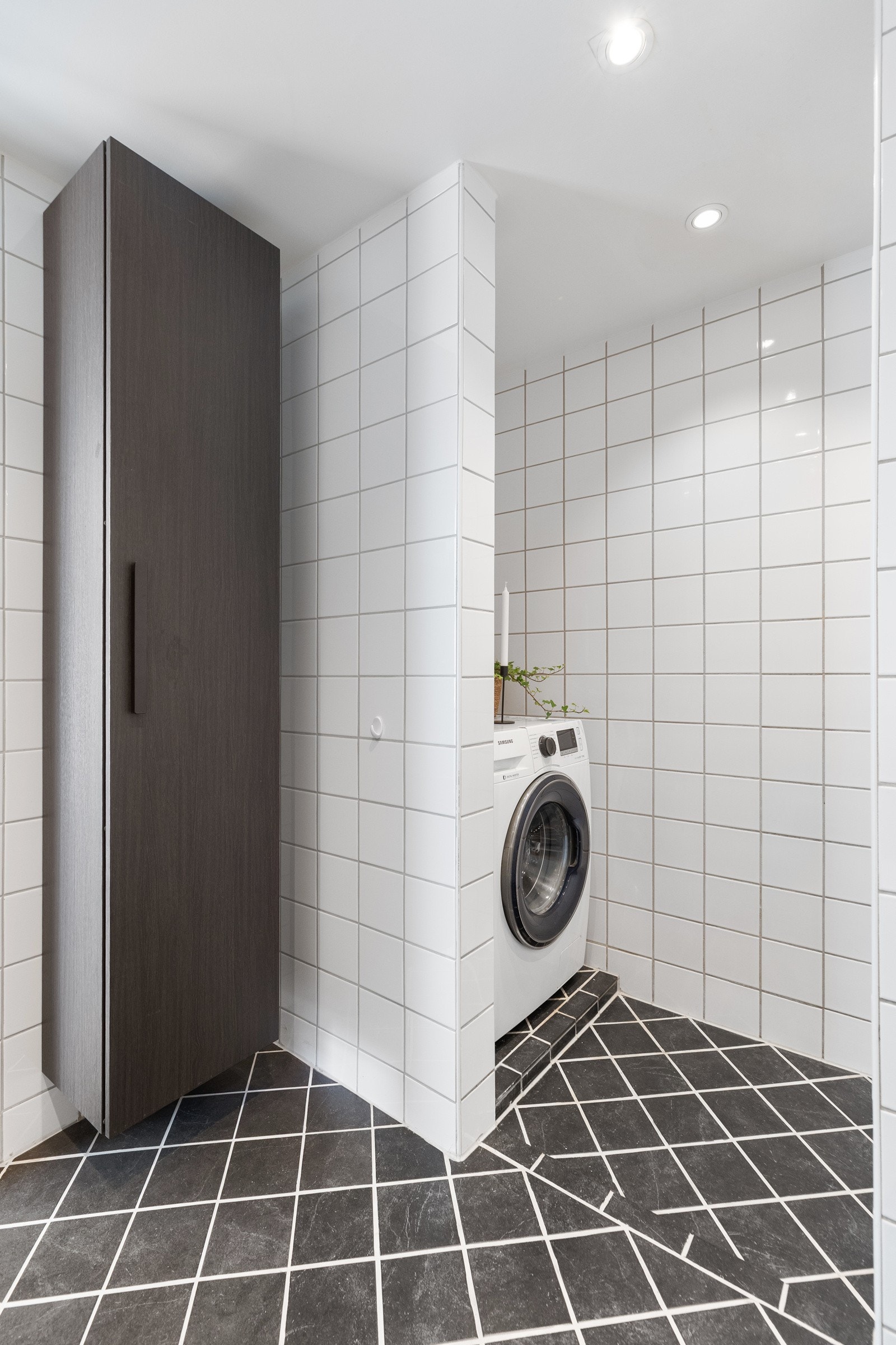 Videre er badet innredet med vegghengt servantinnredning med speil, overlys og stikkontakt over servanten Galleribilde