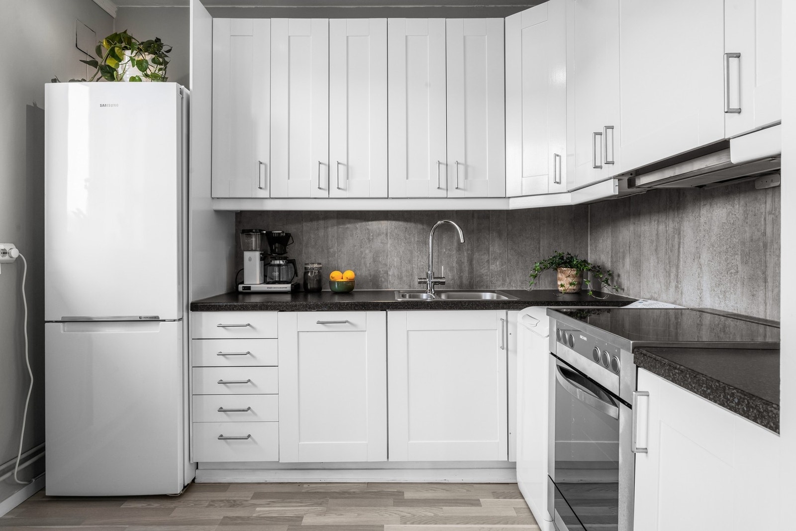 Løsningen gir godt med både arbeidsflater langs benkeplaten samt oppbevaring i skap og skuffer. Galleribilde