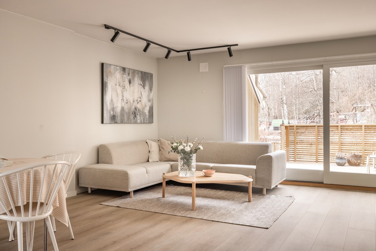 Romslig stue med åpen løsning mot spisestuen og kjøkkenet, som gir et luftig og sosialt oppholdsrom. Galleribilde