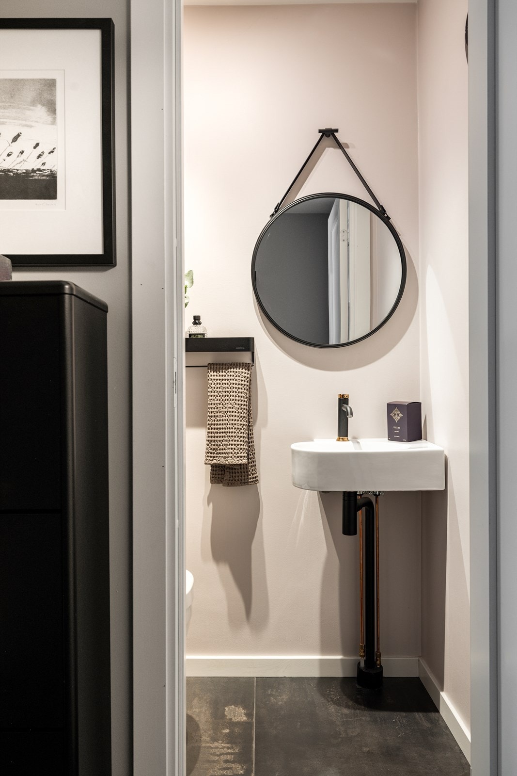 Moderne toalettrom i tilknytning til entréen med mørke gulvfliser og svarte detaljer. Galleribilde