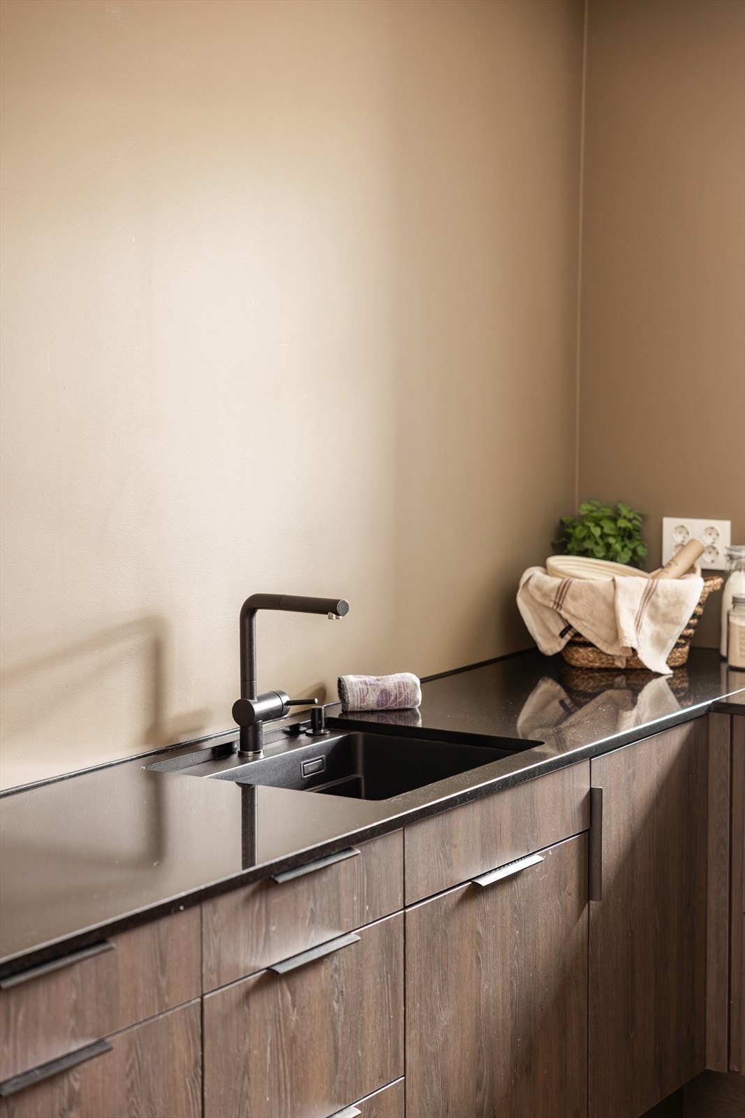 Benkeplaten er i stein med nedfelt oppvaskkum i sort antrasitt, utstyrt med ettgreps svingbart blandebatteri. Galleribilde