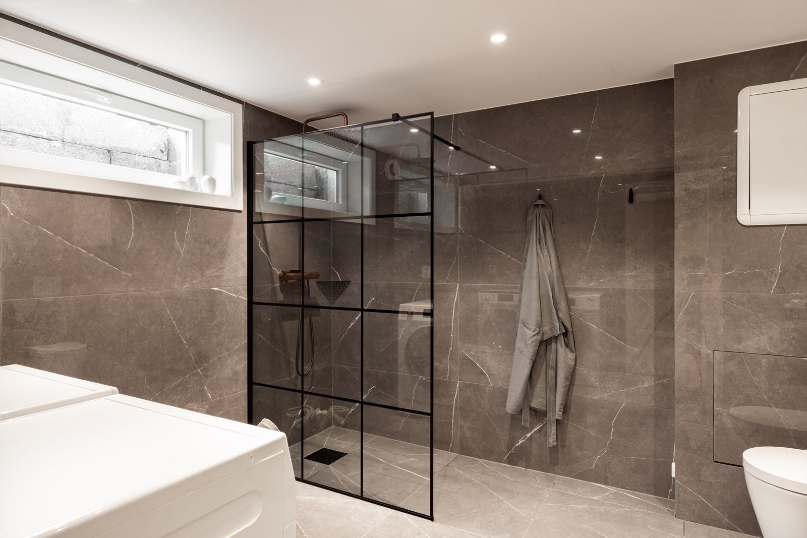 Flislagt bad og vaskerom i kjelleren som ble totalrenovert i 2022. Galleribilde