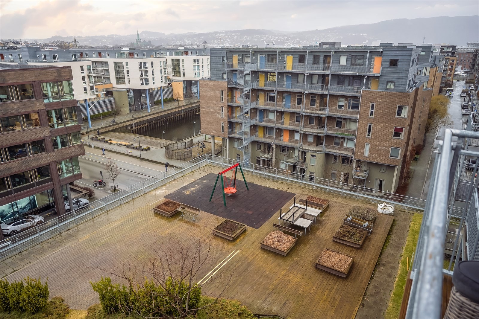 Leilighetens beliggenhet i bygget sørger for rikelig med luft fra naboer. Her ser man ned mot sameiets private terrasse og takhage. Her kan du fint invitere til sosiale lag på en varm sommerdag. Galleribilde