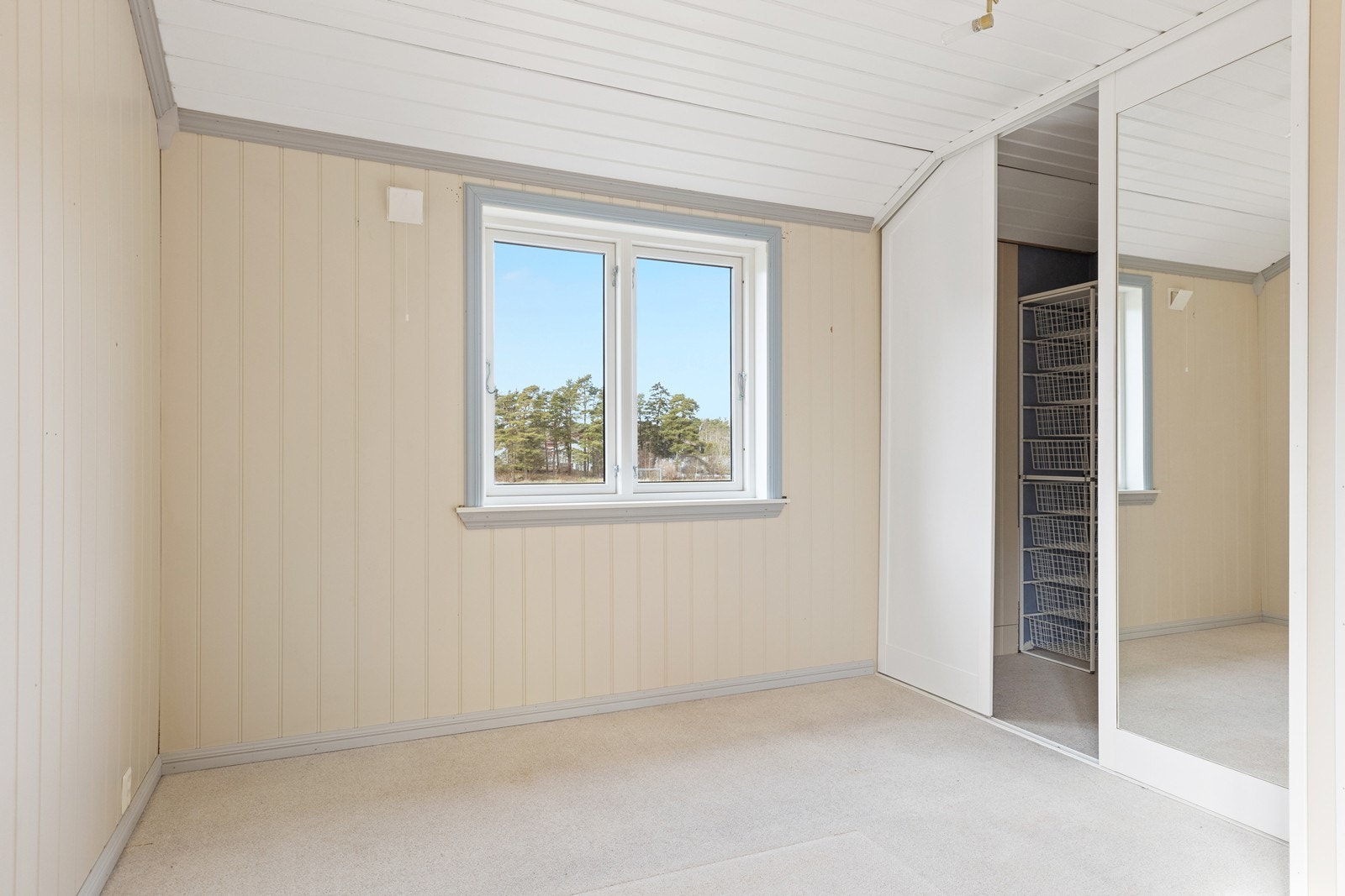 Hovedsoverommet i 2. etasje er ekstra romslig, med belegg på gulvet og malt panel på vegger og i himling. Det er integrert walk-in garderobe med skyvedører Galleribilde