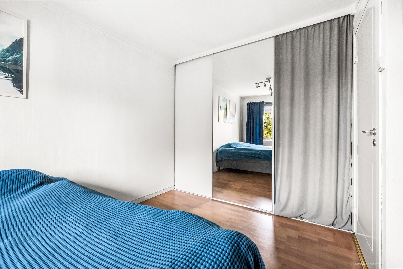 Det er skyvedørsgarderobe alngs en vegg. Galleribilde