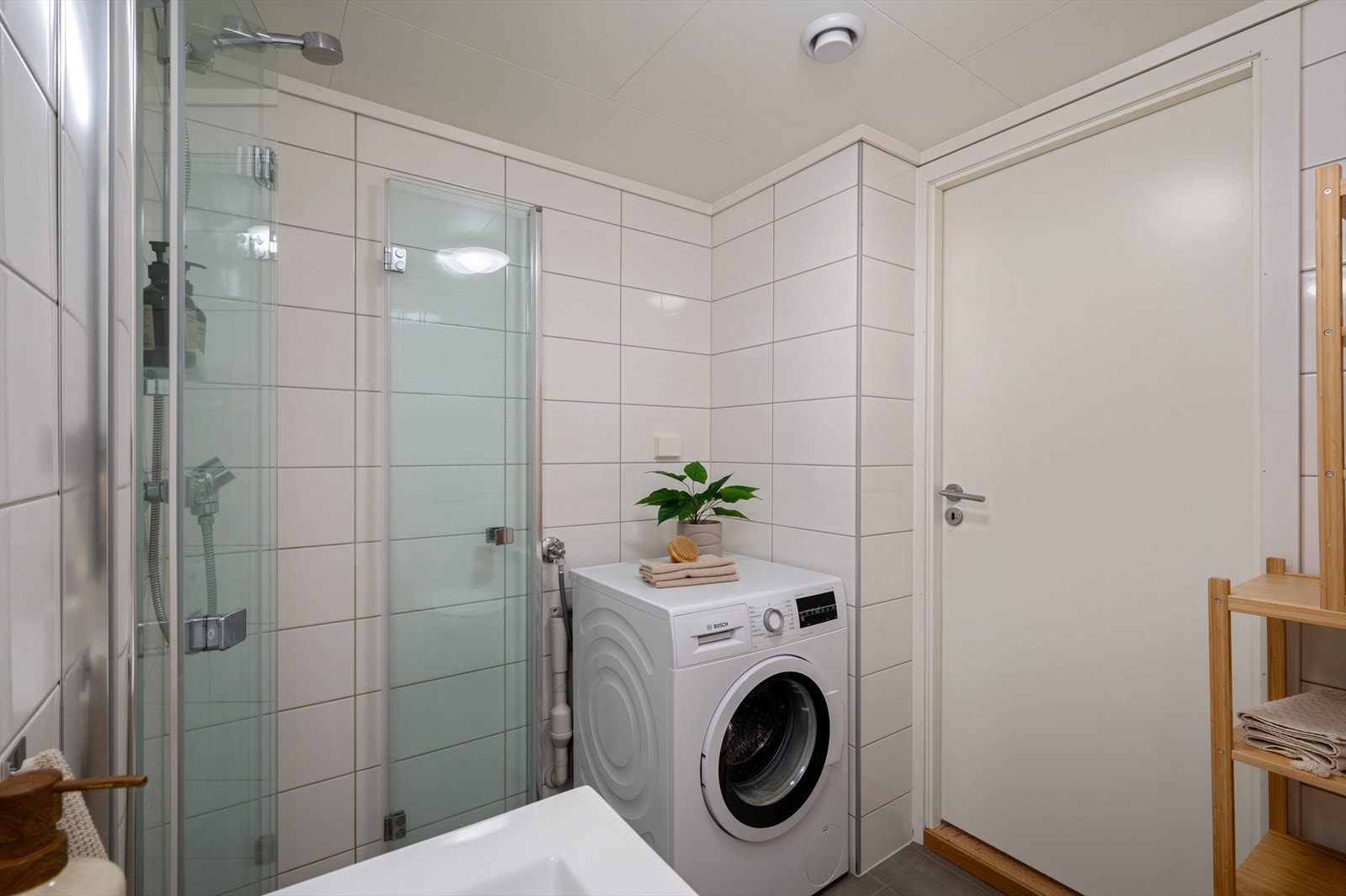 - Badet er innredet med benkeskap med servant, dusjdører i glass, vegghengt toalett, opplegg for vaskemaskin og fordelerskap til "rør i rør" vannforsyning - Galleribilde