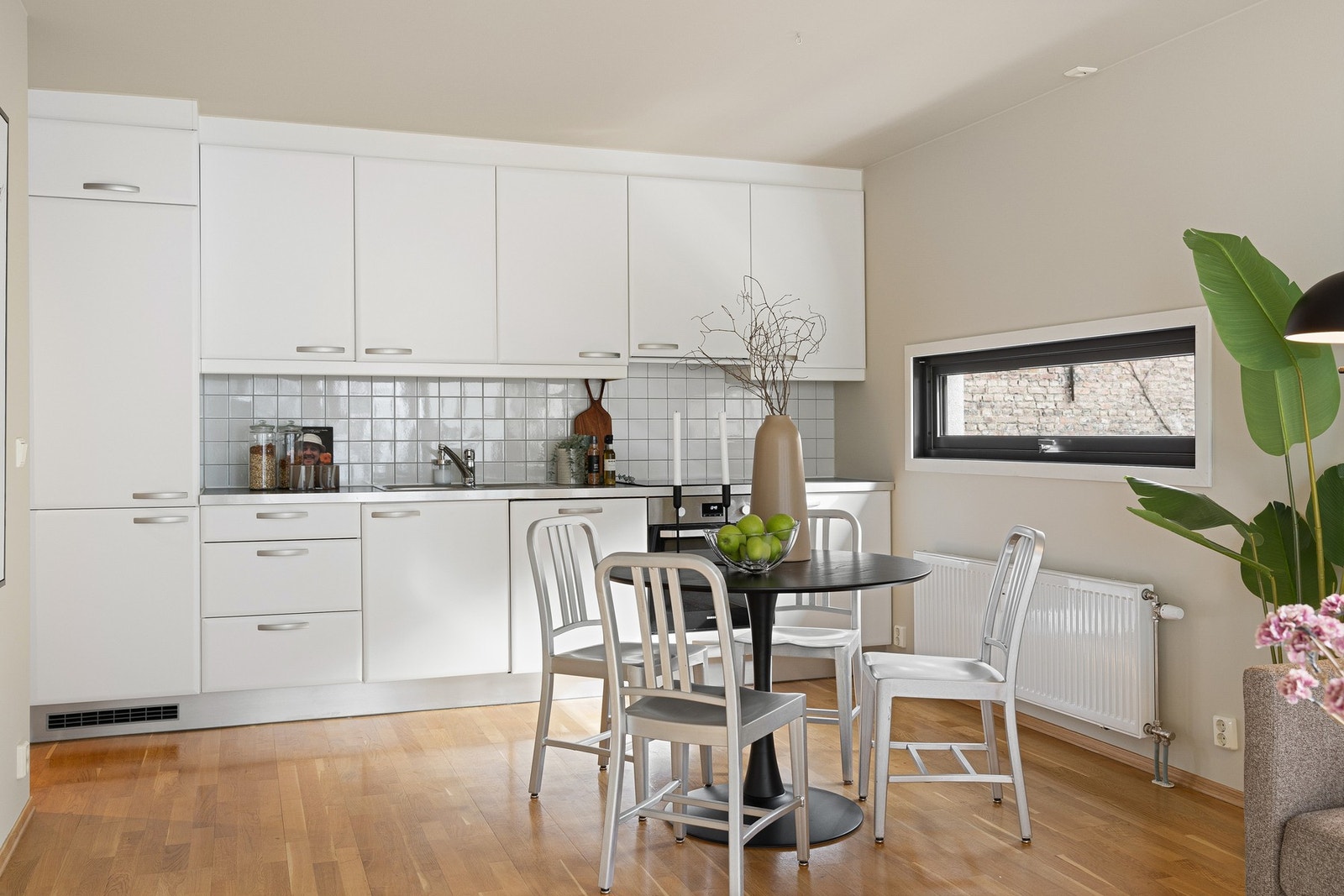 Kjøkken med glatte hvite fronter og integrerte hvitevarer. Godt med skapplass. Her kan fronter enkelt byttes eller lakkeres for å sette ditt personlige preg. Galleribilde