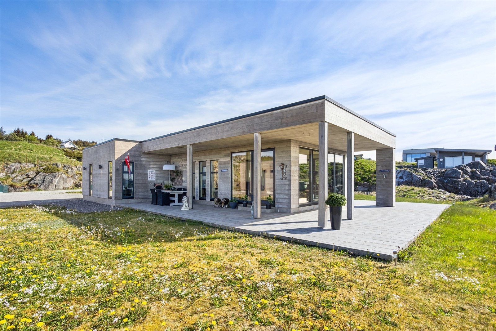 Et fantastisk flott arkitektonisk bygg som er omkranset av flere flotte uteplasser på en 117 kvm markterrasse belagt med betongheller. Galleribilde