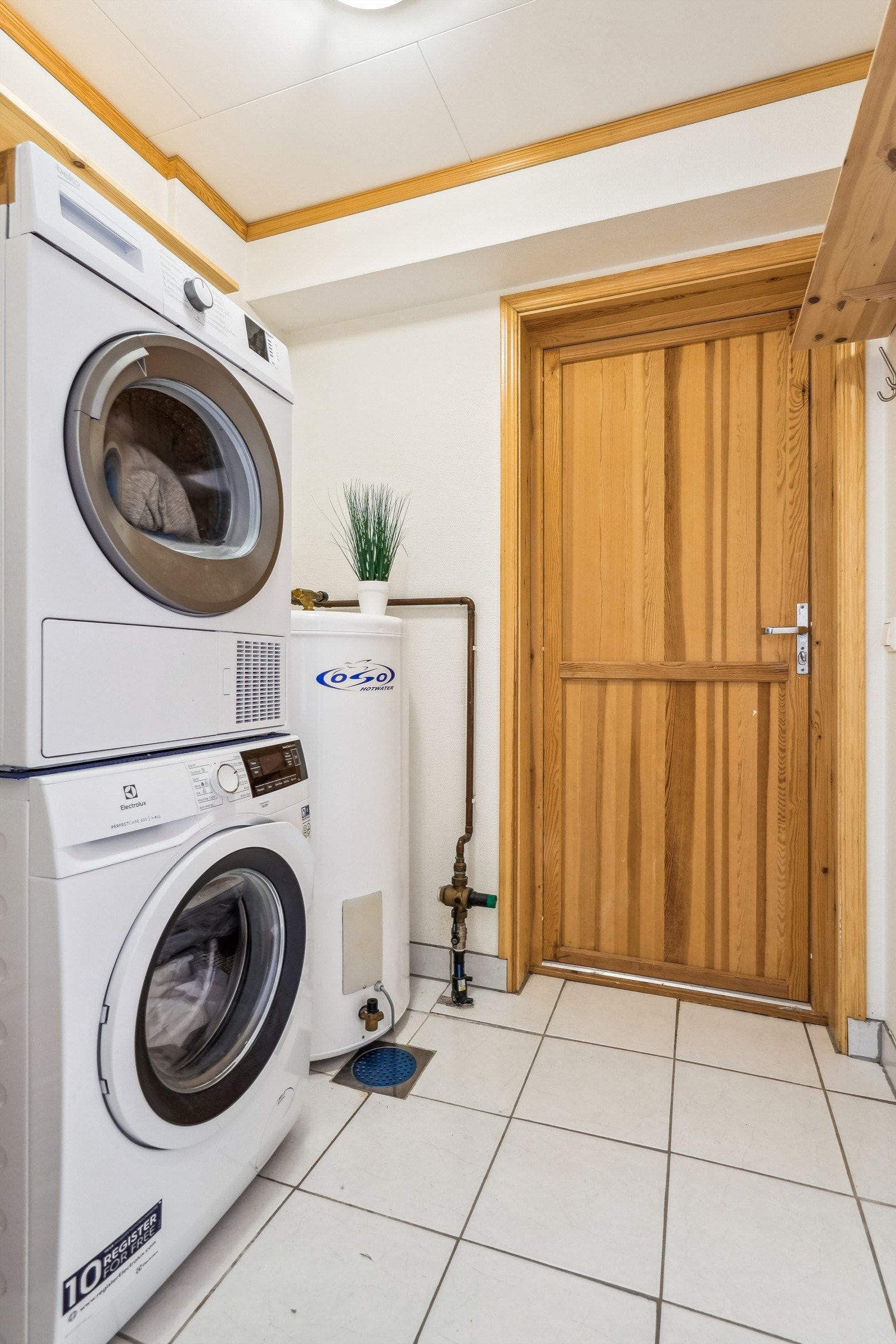 Vaskerom med fliset gulv. Opplegg for vaskemaskin. Varmtvannstank montert i rommet. Direkte tilkomst til garasje. Galleribilde