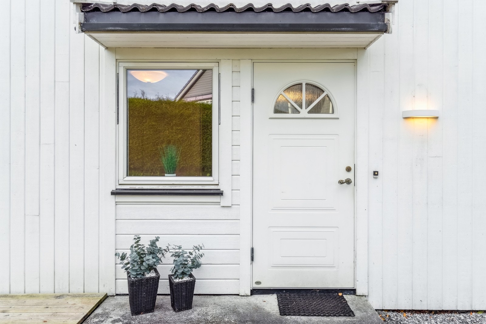 Hyggelig inngangsparti med takoverbygg og utebelysning. Galleribilde