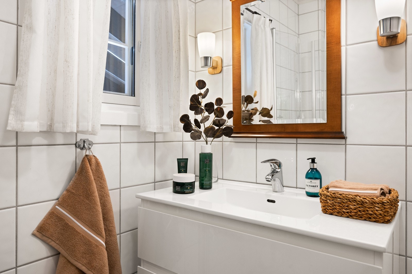 Innredningen har slette fronter, skuffer og heldekkende servant. Speil på vegg over servanten. Galleribilde