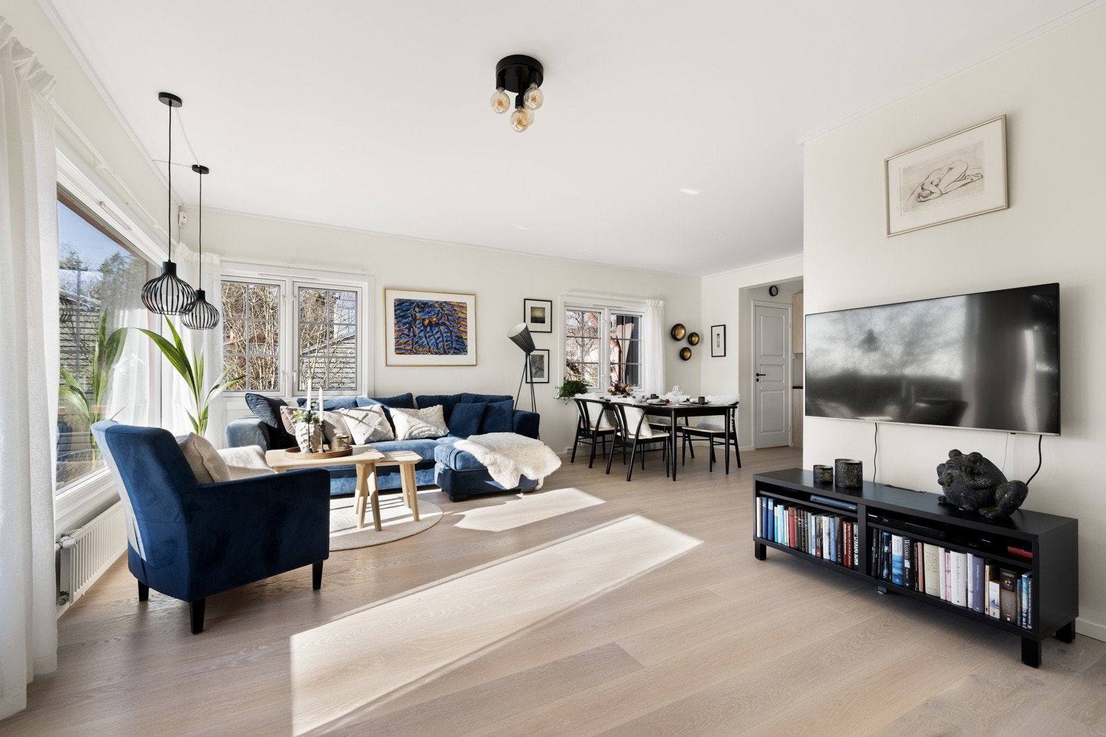 Stor luftig vinkelstue med luftig takhøyde på 2,55 meter, flott enstavs eikeparkett og store vindusflater mot sydvest, nordvest og gjennomgående lys fra nordøst. Galleribilde